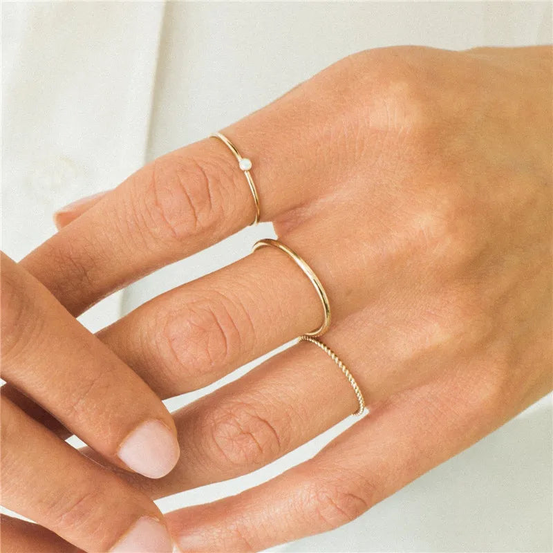 woman's hands wearing minimalist stacking rings 