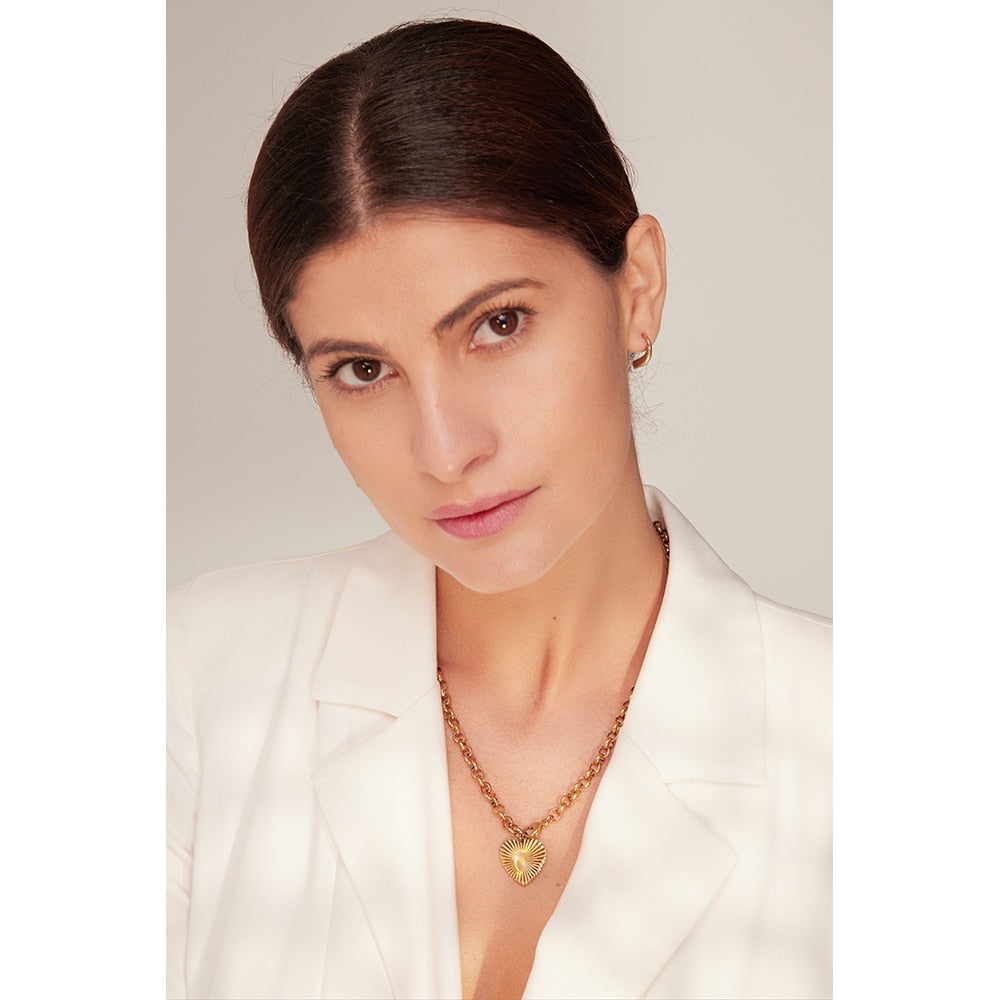 woman wearing gold chain necklace with heart pendant